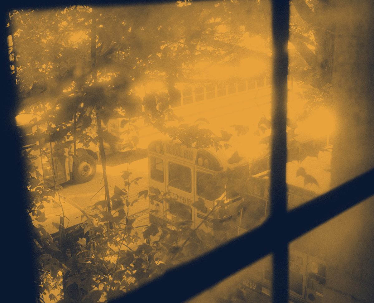 Buses vistos desde una ventana, en tonos cálidos de marca